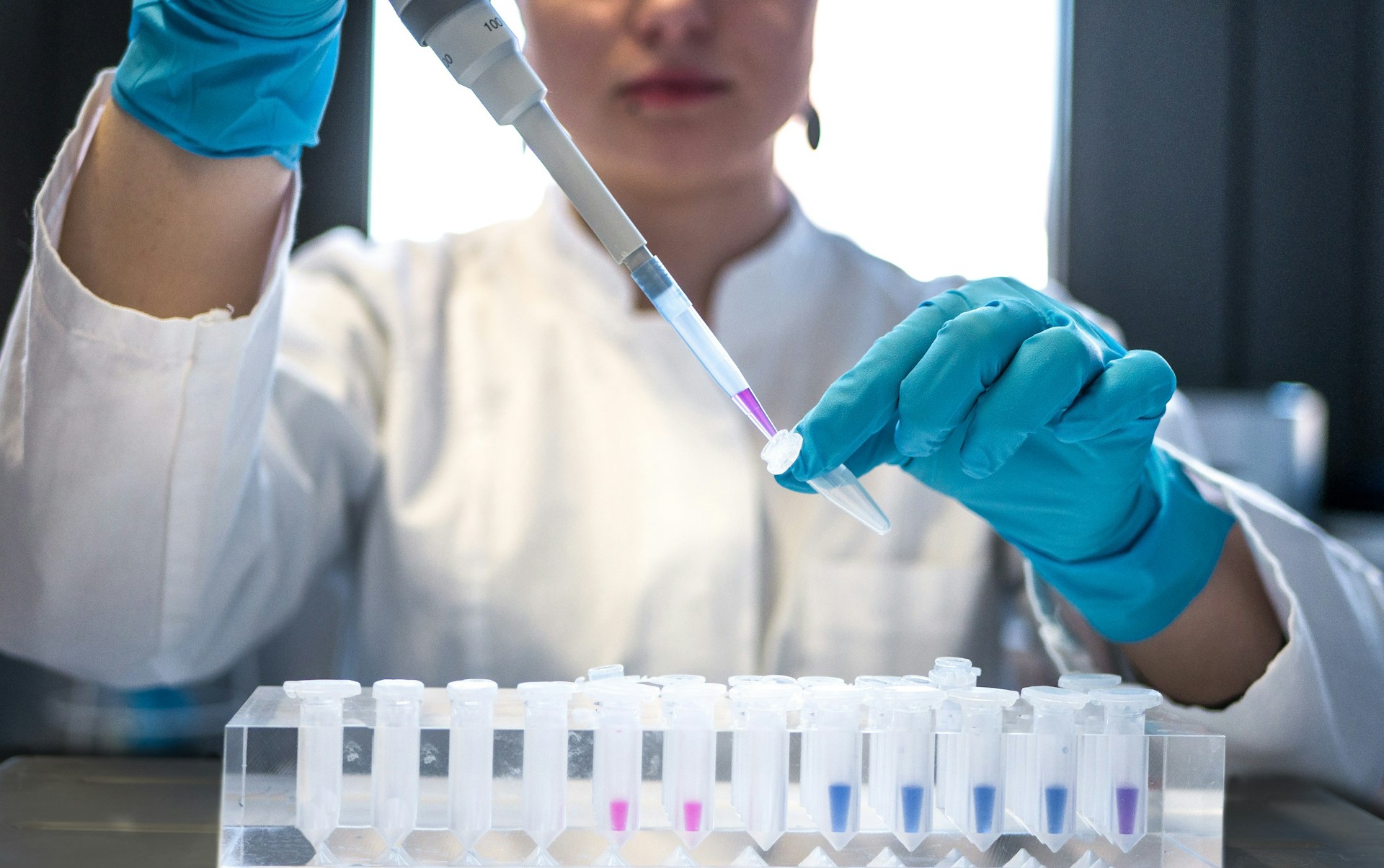 chemikerin führt experiment durch mit spritze und fläschchen